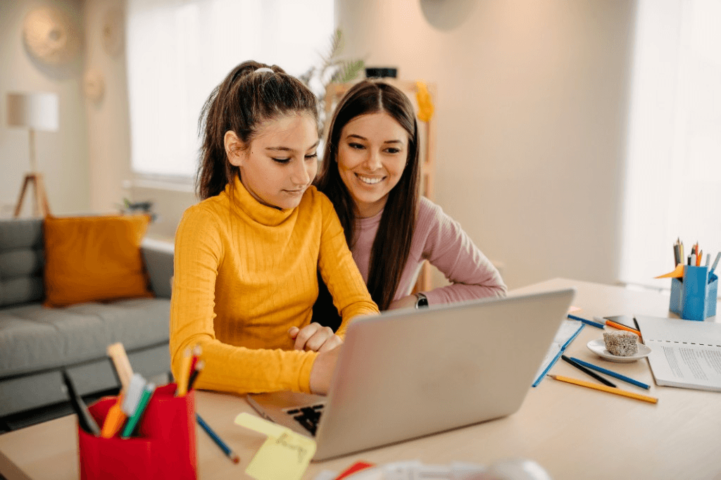Two people collaborating at a desk with a laptop—learning and connection